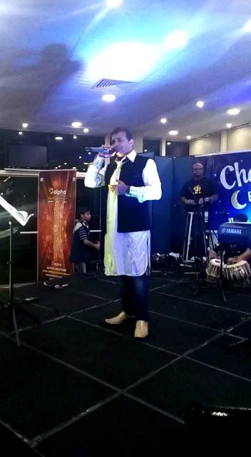 A man is singing into a microphone on a stage