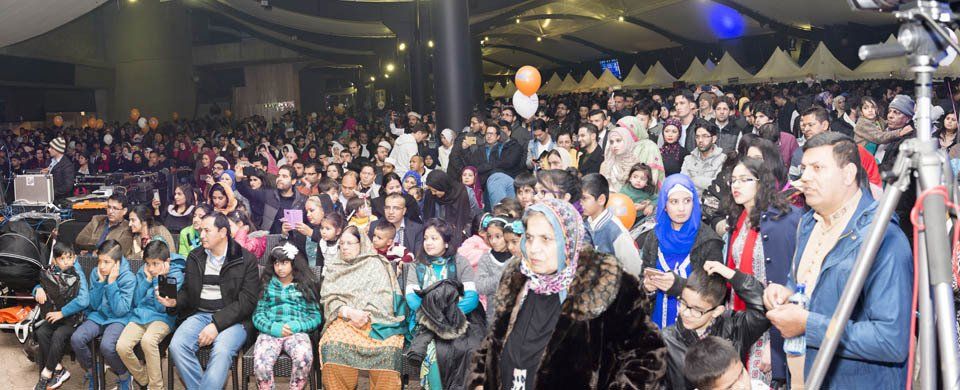 A large crowd of people are sitting in a large room.