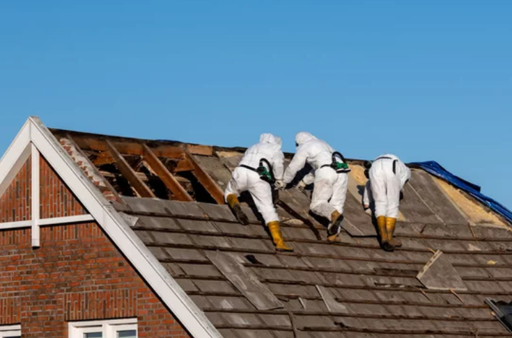 Professionals in protective suits carefully removing asbestos-cement.