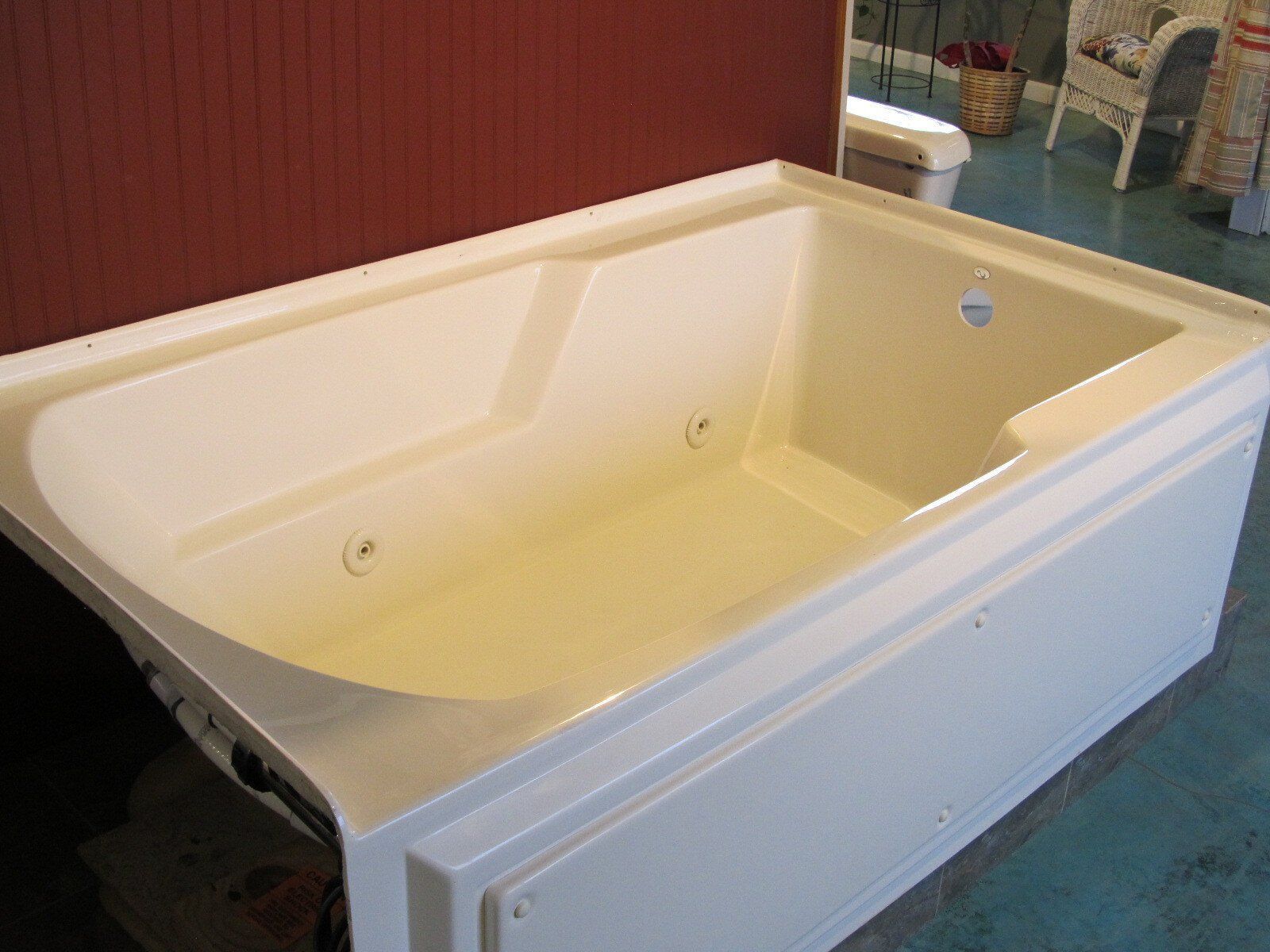 A white bathtub is sitting on a blue floor in a bathroom.