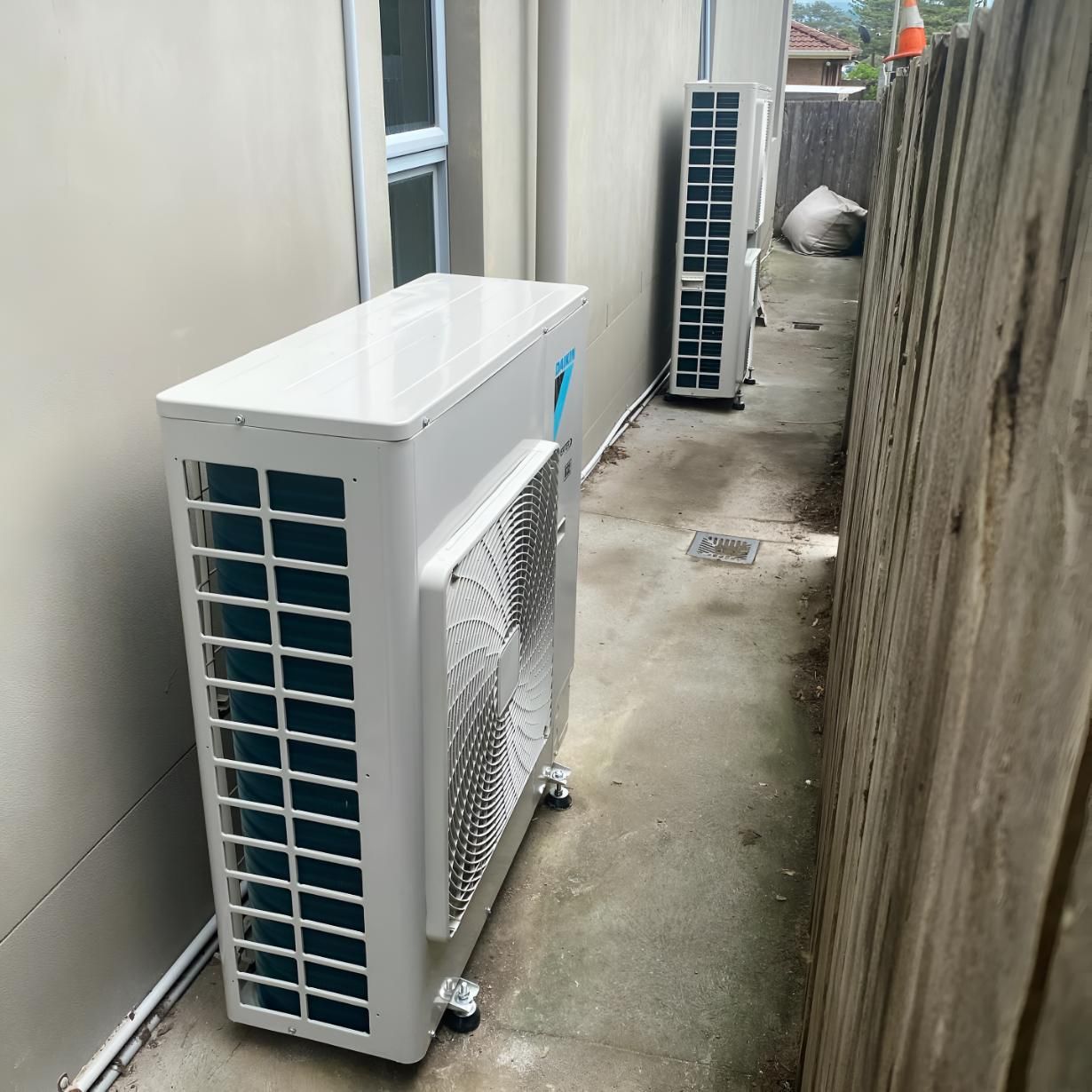 Two Air Conditioners Are Sitting on the Side — Kiama Air Conditioning in Albion Park Rail, NSW
