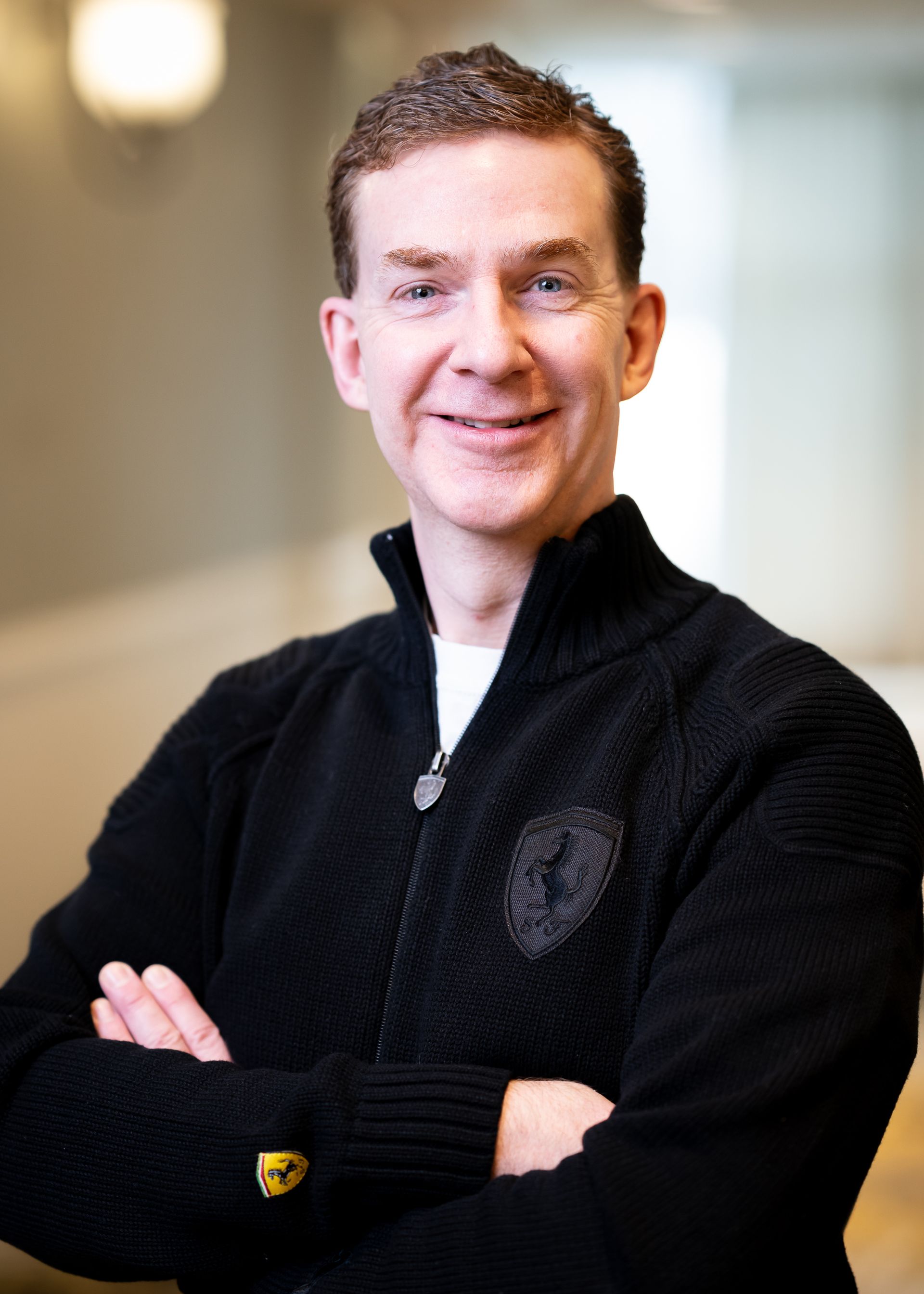 A smiling doctor in a lab coat with a stethoscope around his neck.