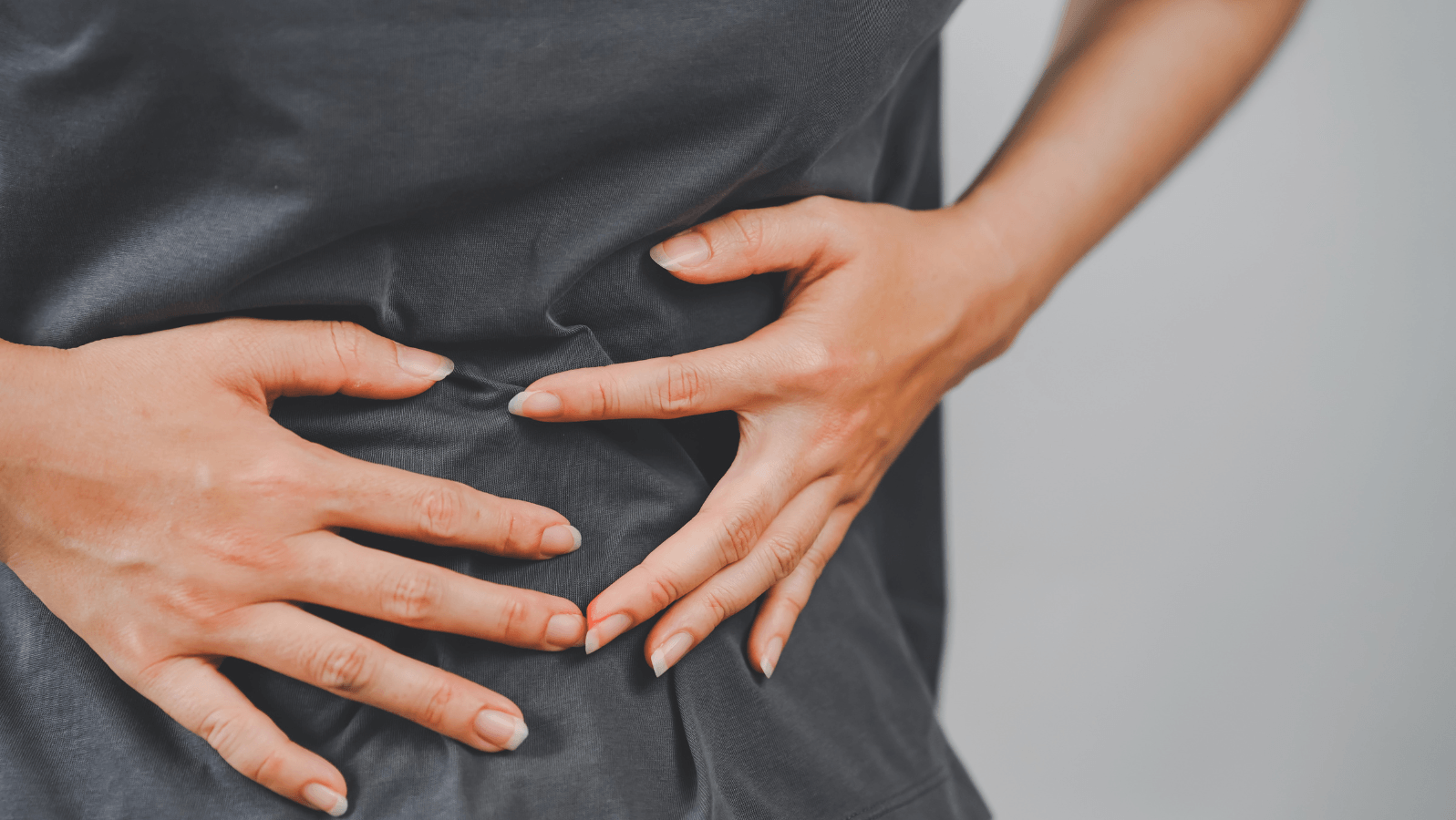 Woman grabbing her stomach while feeling ill