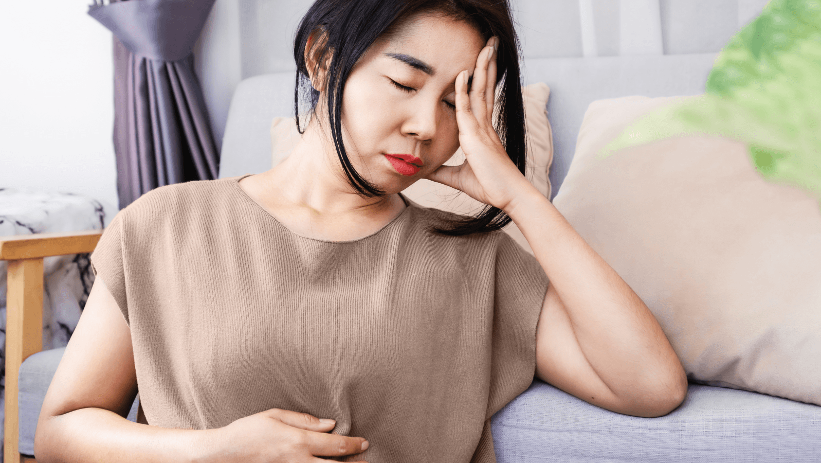 Young woman grabbing her stomach while feeling ill