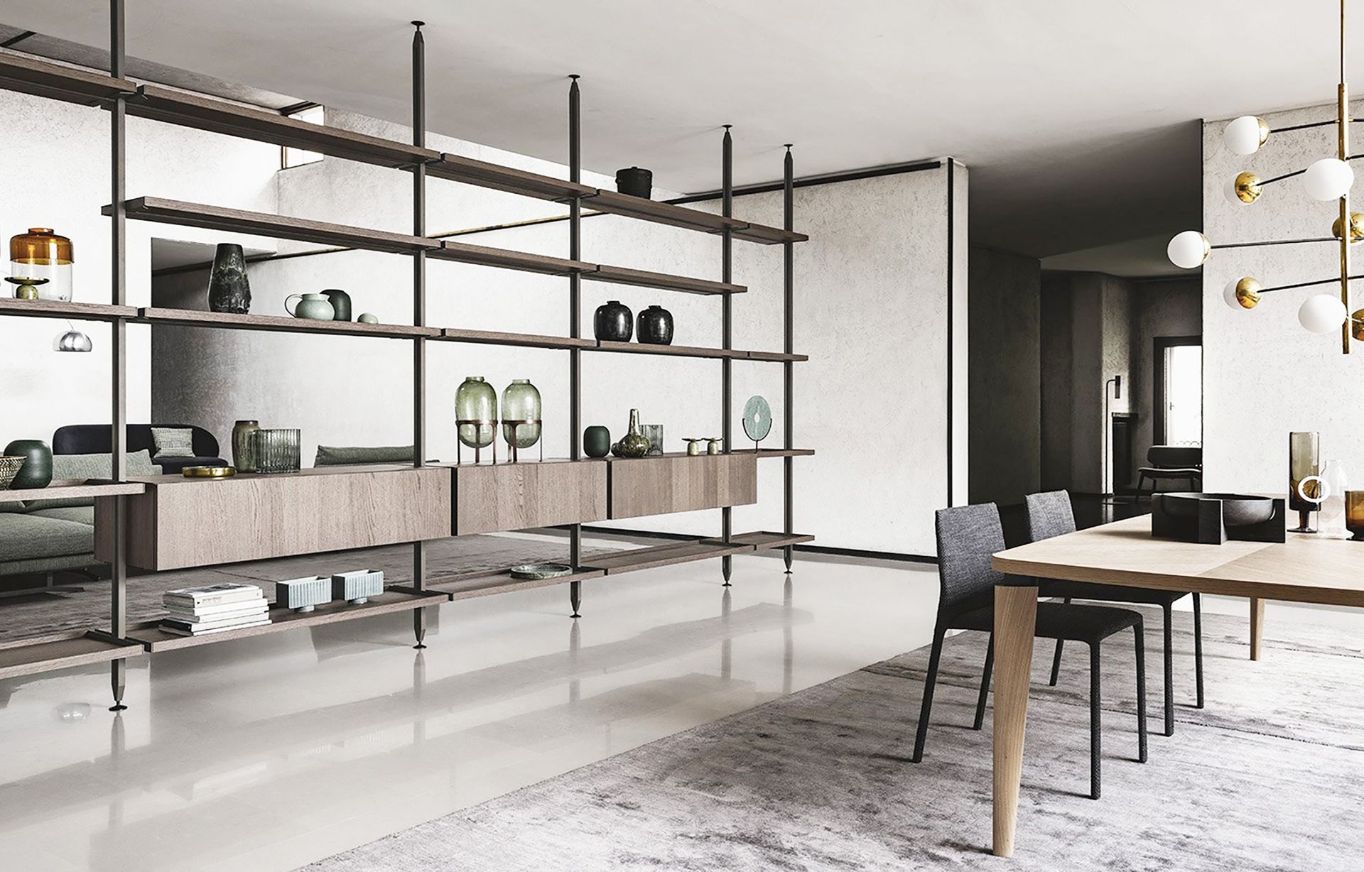 Soggiorno e sala da pranzo moderni a pianta aperta con scaffalature nere, tavolo in legno e decorazioni bianche.