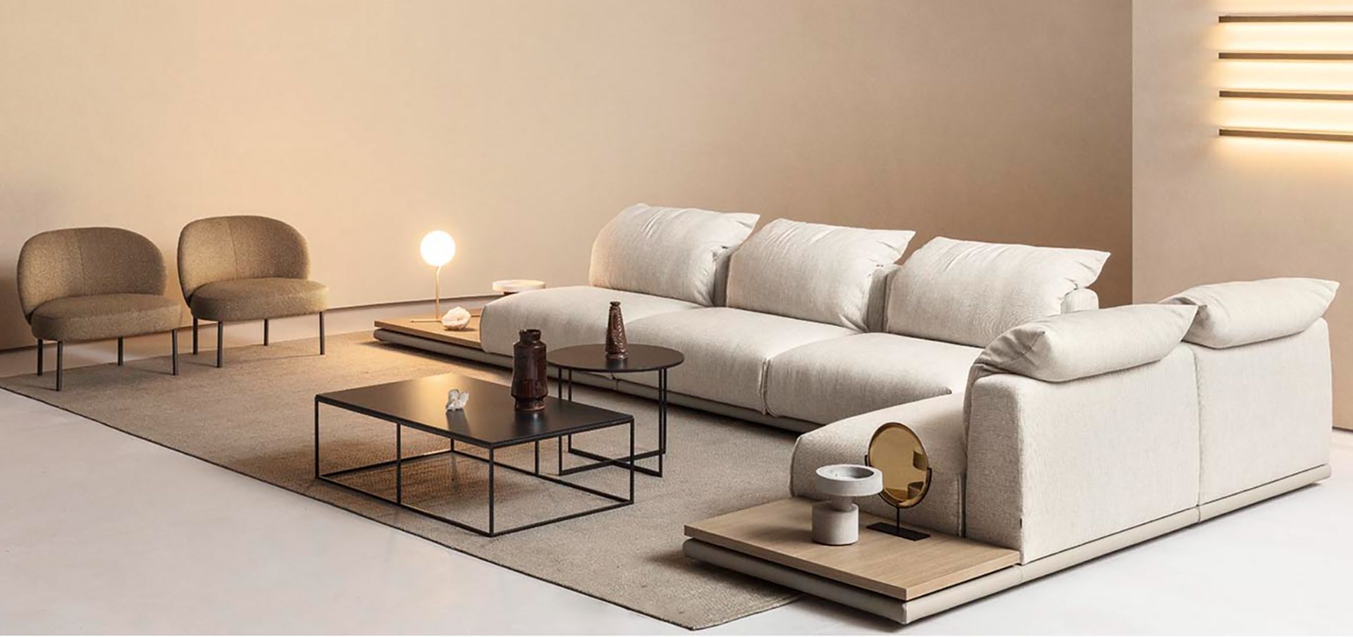 Soggiorno con centro multimediale integrato in tonalità neutre, dotato di TV, librerie e divano scuro.