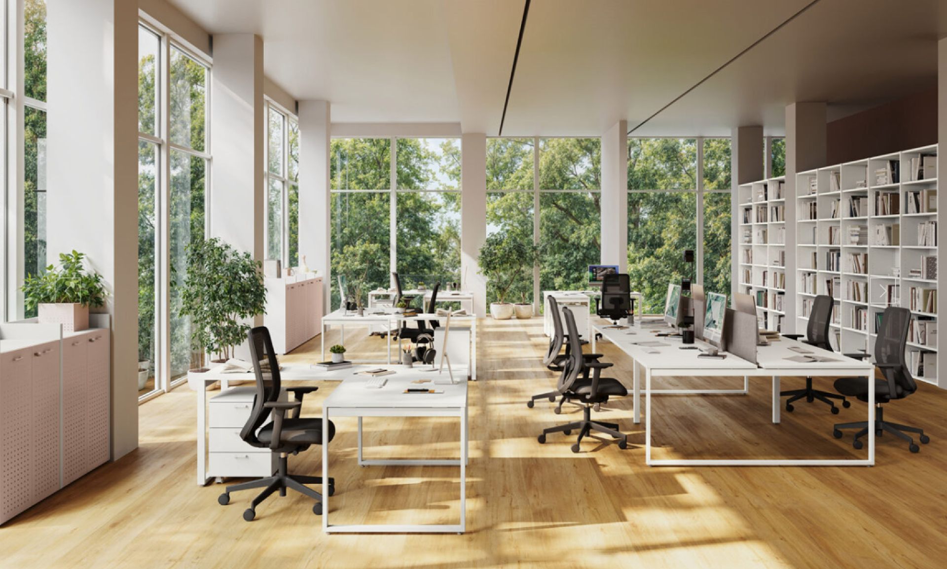 Ufficio moderno open space con scrivanie, sedie, librerie e ampie finestre con vista sugli alberi.
