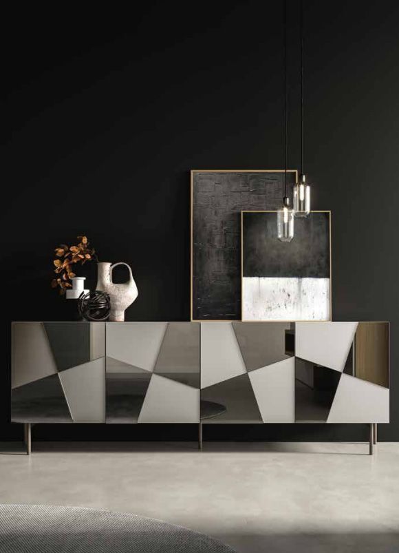 Credenza geometrica moderna con opere d'arte e vasi contro una parete nera.