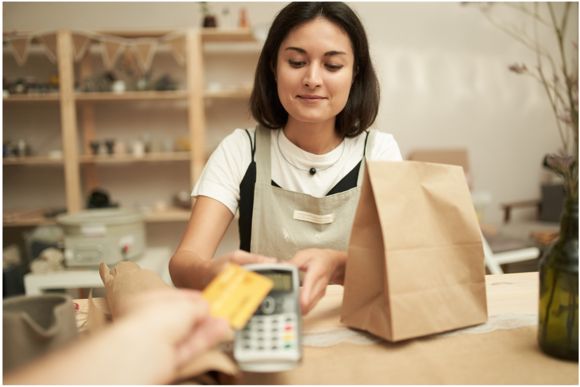 Une femme avec une machine à payer