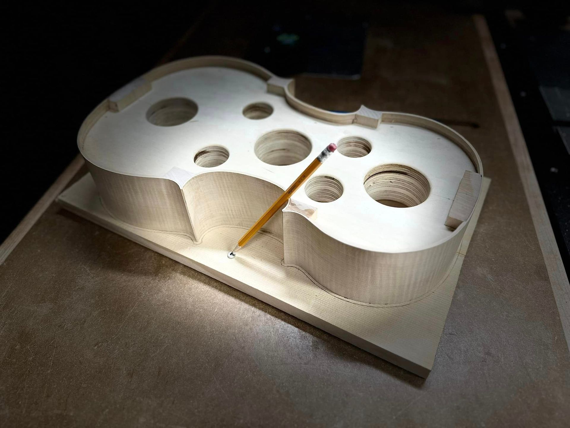 A violin is sitting on a table with a black background