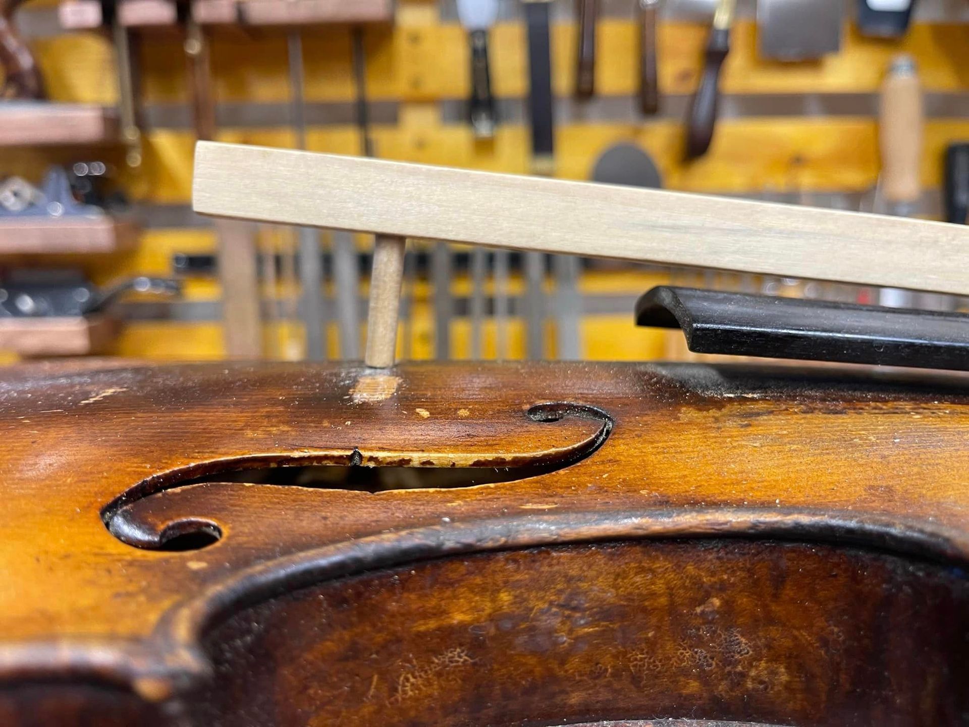 A piece of wood is sitting on top of a violin