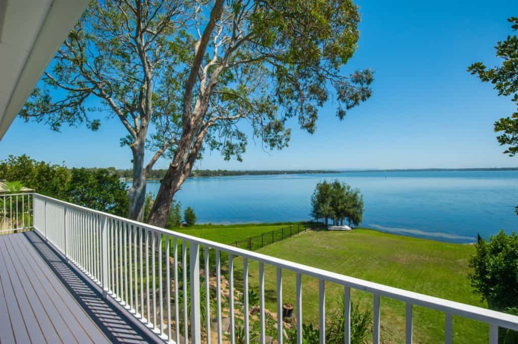 A View of A Lake from A Balcony with A White Railing — Blue Horizon Projects in Bateau Bay, NSW