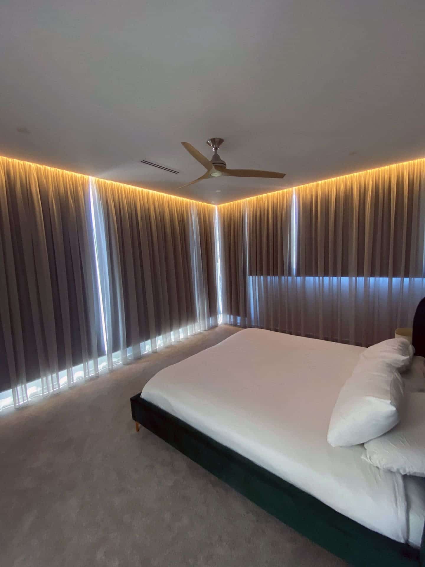 A Bedroom with A Large Bed and A Ceiling Fan — Blue Horizon Projects in Bateau Bay, NSW