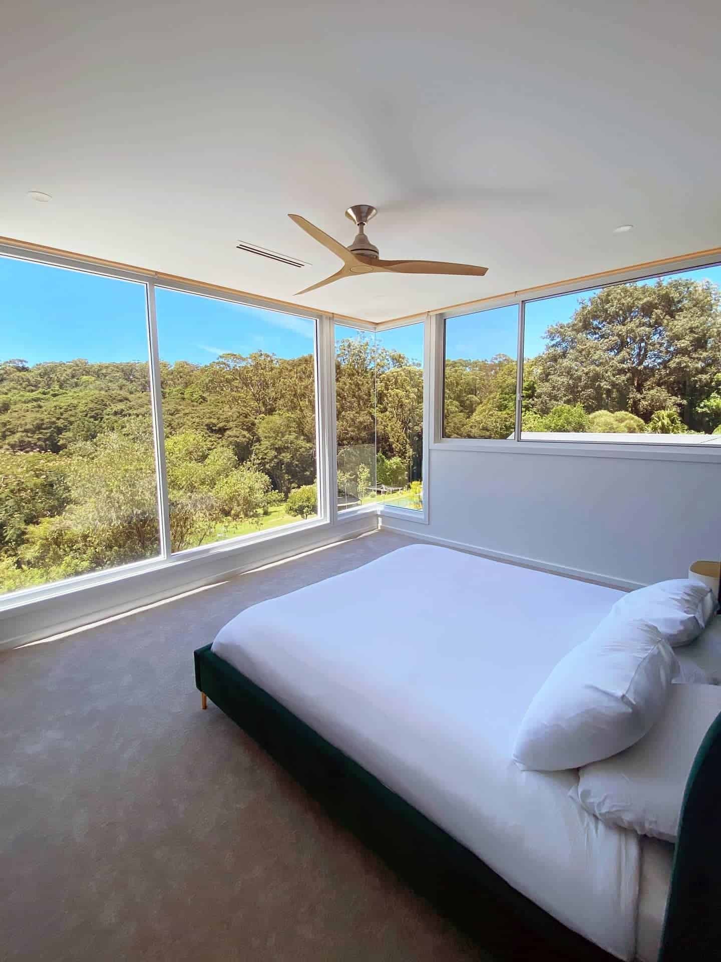 A Bedroom with A Large Bed and A Ceiling Fan — Blue Horizon Projects in Bateau Bay, NSW