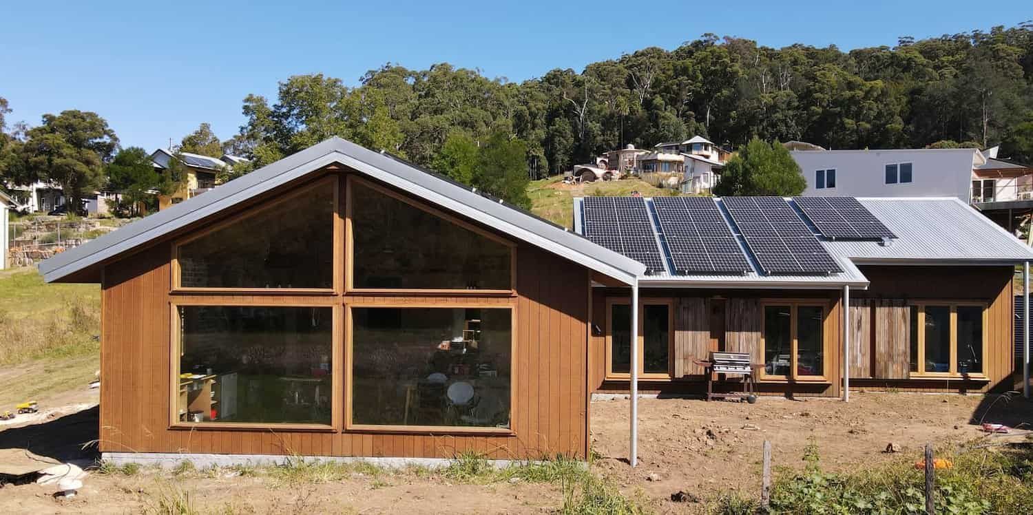 A House with A Lot of Windows and Solar Panels on The Roof — Blue Horizon Projects in Bateau Bay, NSW