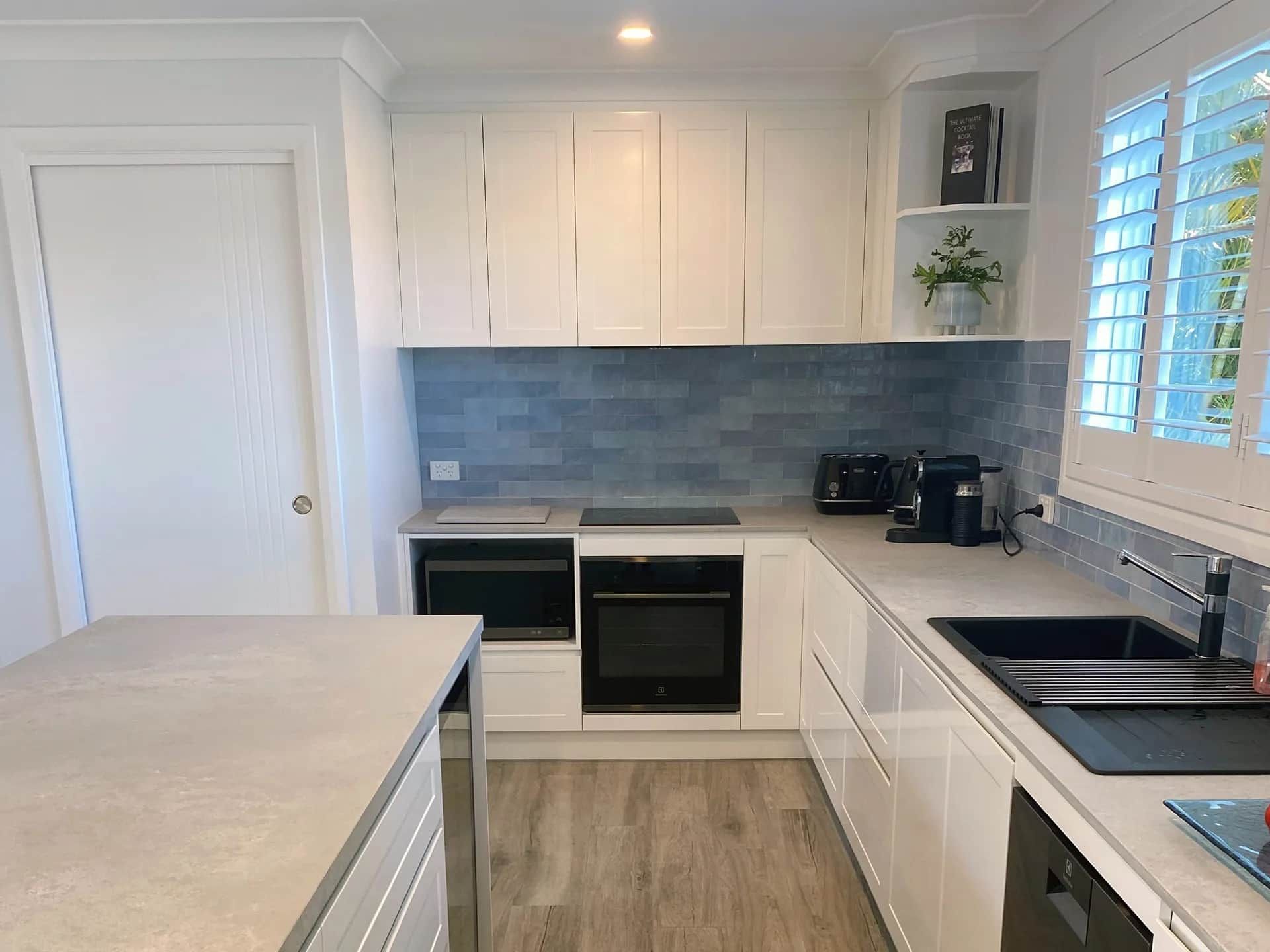 A Kitchen with White Cabinets and Stainless Steel Appliances — Blue Horizon Projects in Bateau Bay, NSW