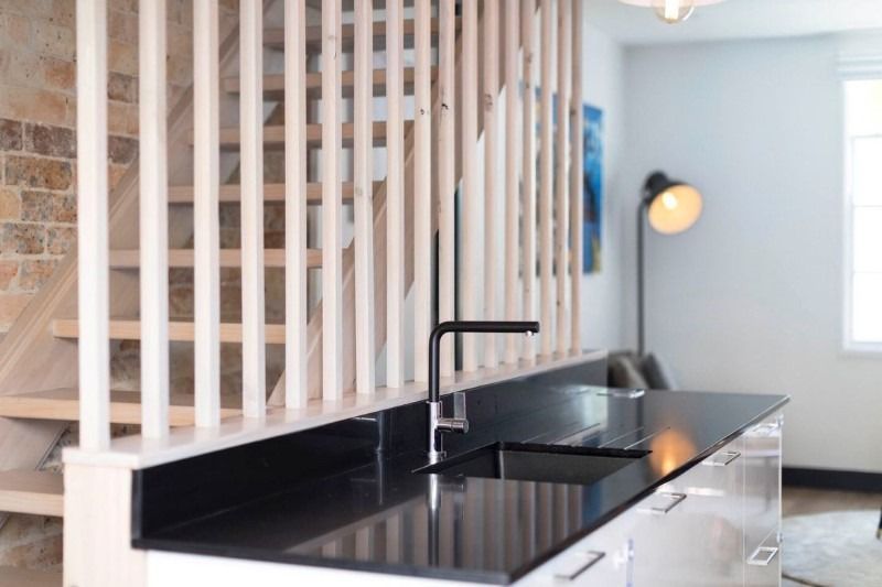 A Kitchen with A Black Counter Top and A Sink — Blue Horizon Projects in Bateau Bay, NSW