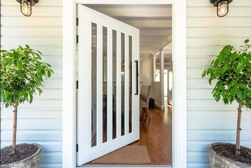 A White Door with Two Potted Plants in Front of It — Blue Horizon Projects in Bateau Bay, NSW