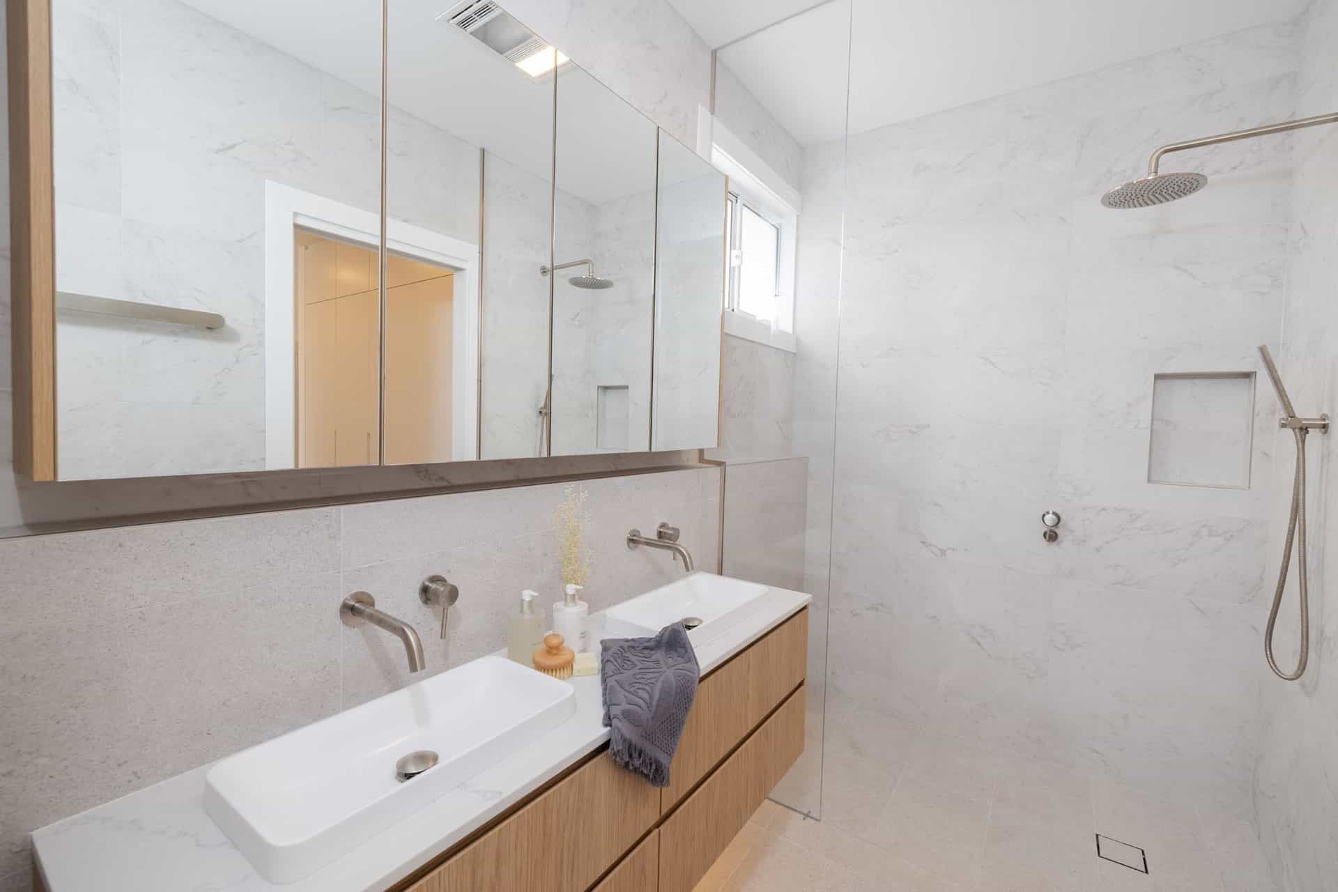 A Bathroom with Two Sinks, a Shower and A Mirror — Blue Horizon Projects in Bateau Bay, NSW