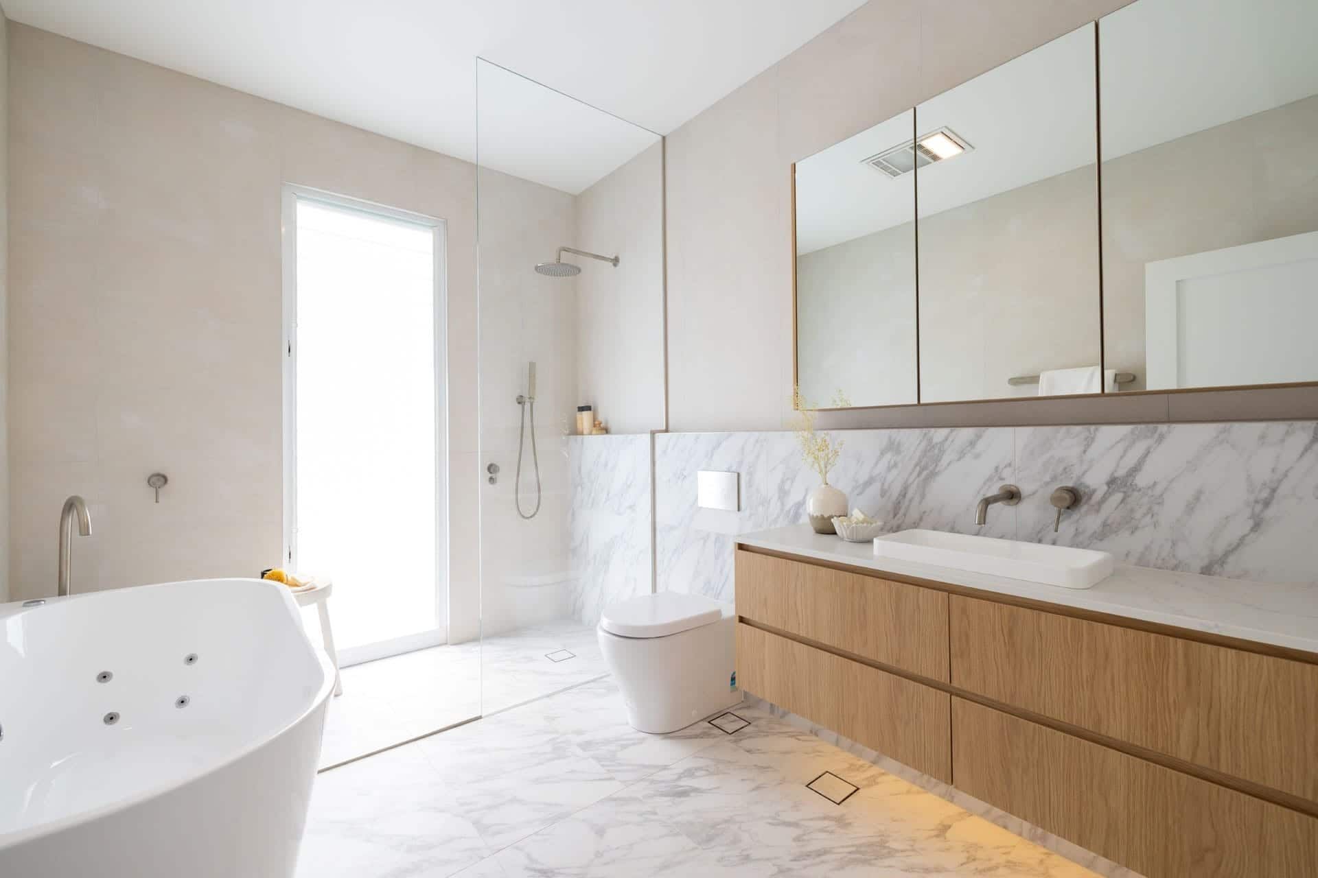 A Bathroom with A Bathtub, Toilet, Sink and Mirrors — Blue Horizon Projects in Bateau Bay, NSW