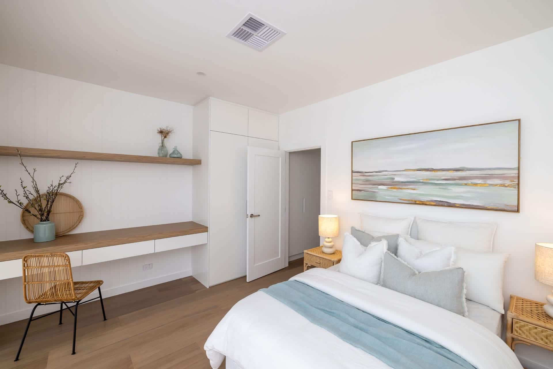 A Bedroom with A Bed, Desk, Nightstands and A Painting on The Wall — Blue Horizon Projects in Bateau Bay, NSW