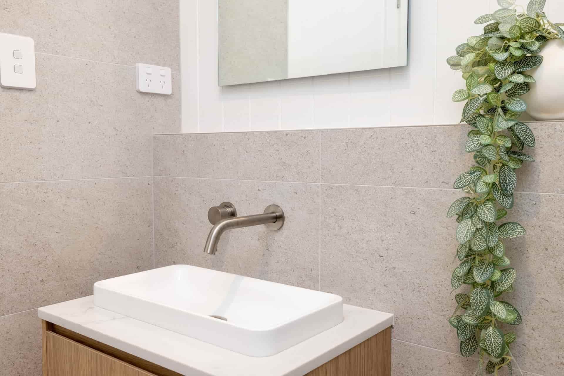 A Bathroom with A Sink, Mirror and Plant — Blue Horizon Projects in Bateau Bay, NSW