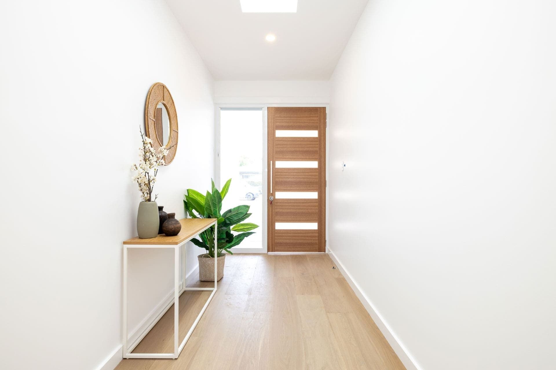 A Hallway with A Wooden Door and A Wooden Table — Blue Horizon Projects in Bateau Bay, NSW
