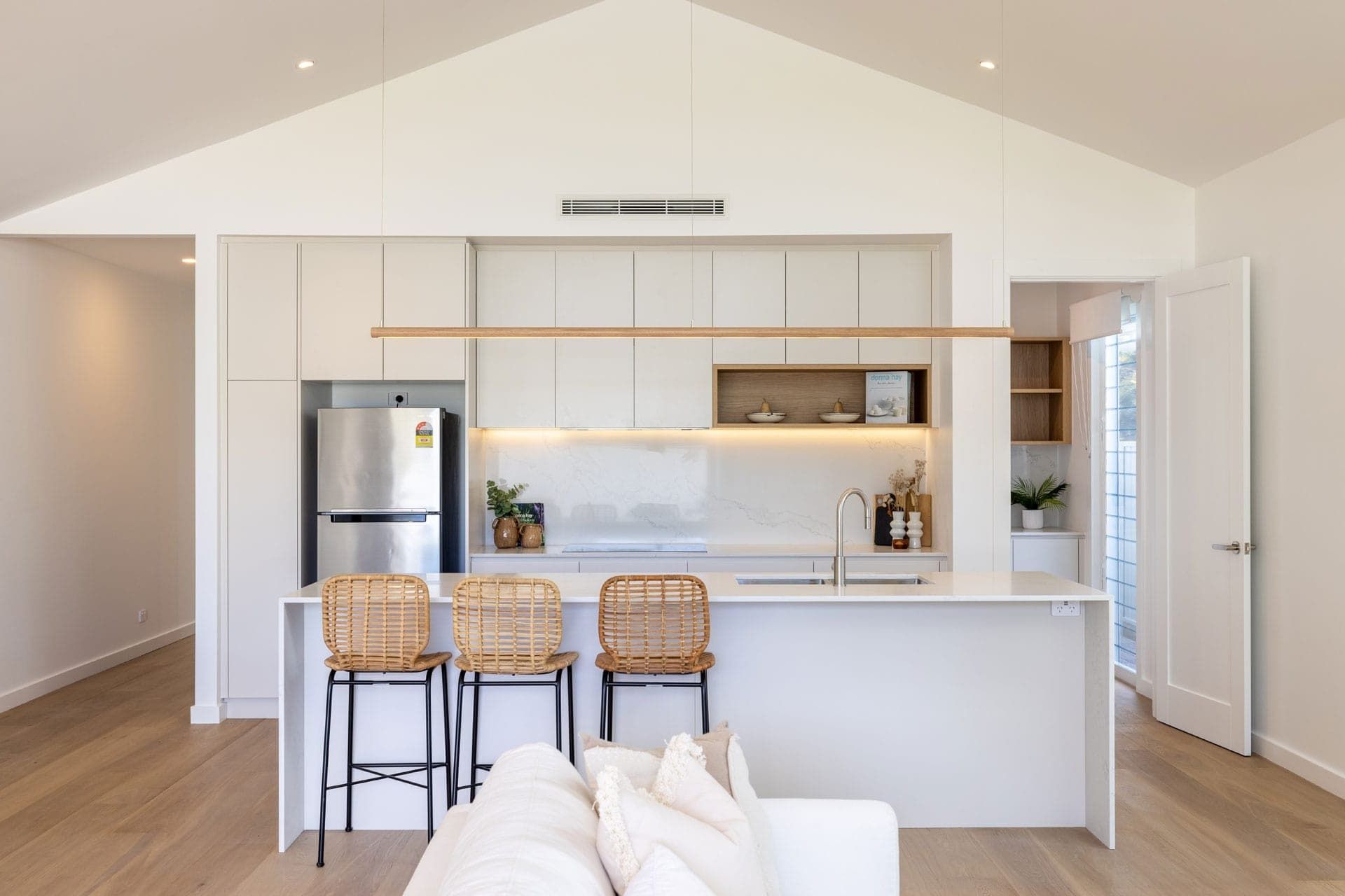 A Kitchen with White Cabinets and A Stainless Steel Refrigerator — Blue Horizon Projects in Bateau Bay, NSW