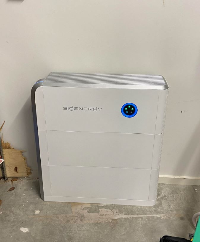 A Sigenergy Solar Battery is Sitting on the Floor in a Garage — Des Mullins Electrical & Solar In Wagga Wagga, NSW
