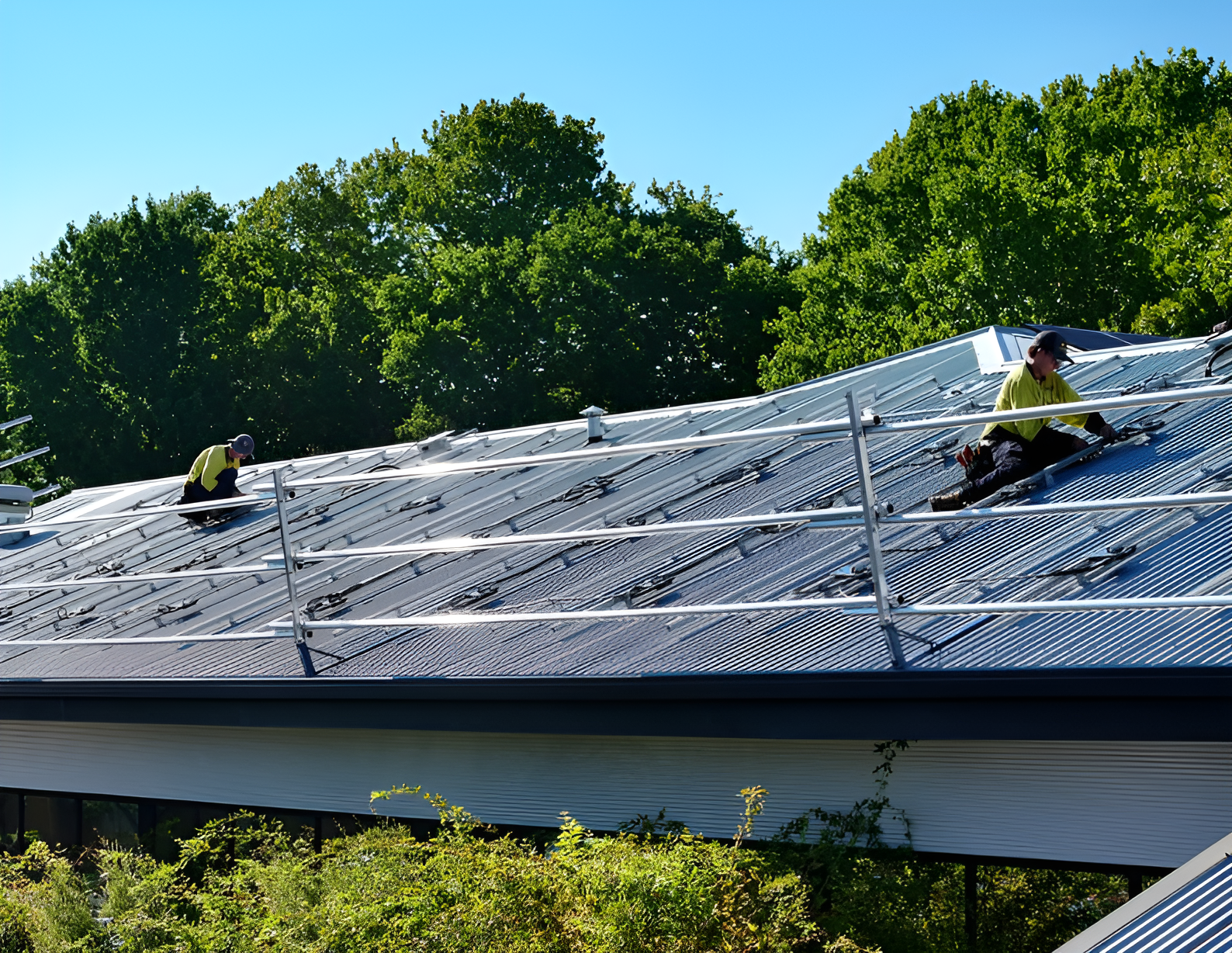 Two Men Are Installing Solar Panels on the Roof of a Building — Des Mullins Electrical & Solar In Wagga Wagga, NSW