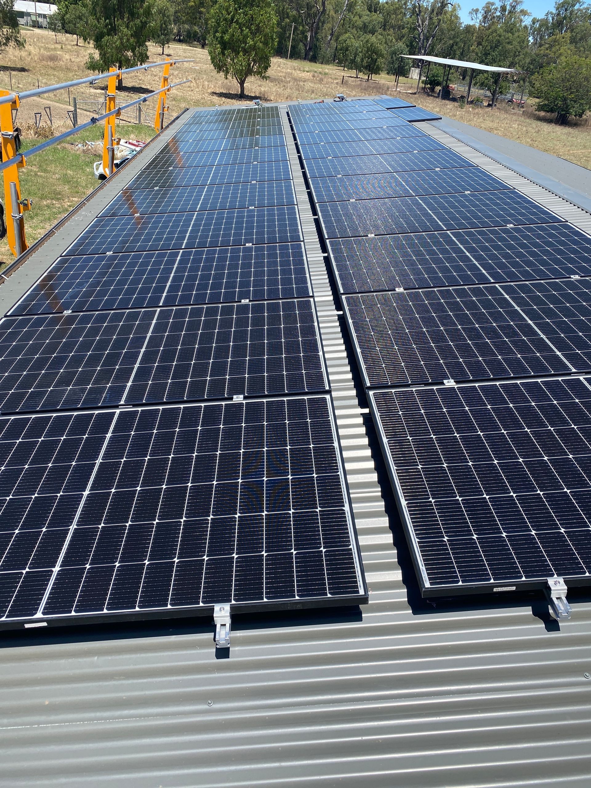 A Row Of Solar Panels Sitting On Top Of A Metal Roof — Des Mullins Electrical & Solar In Wagga Wagga, NSW