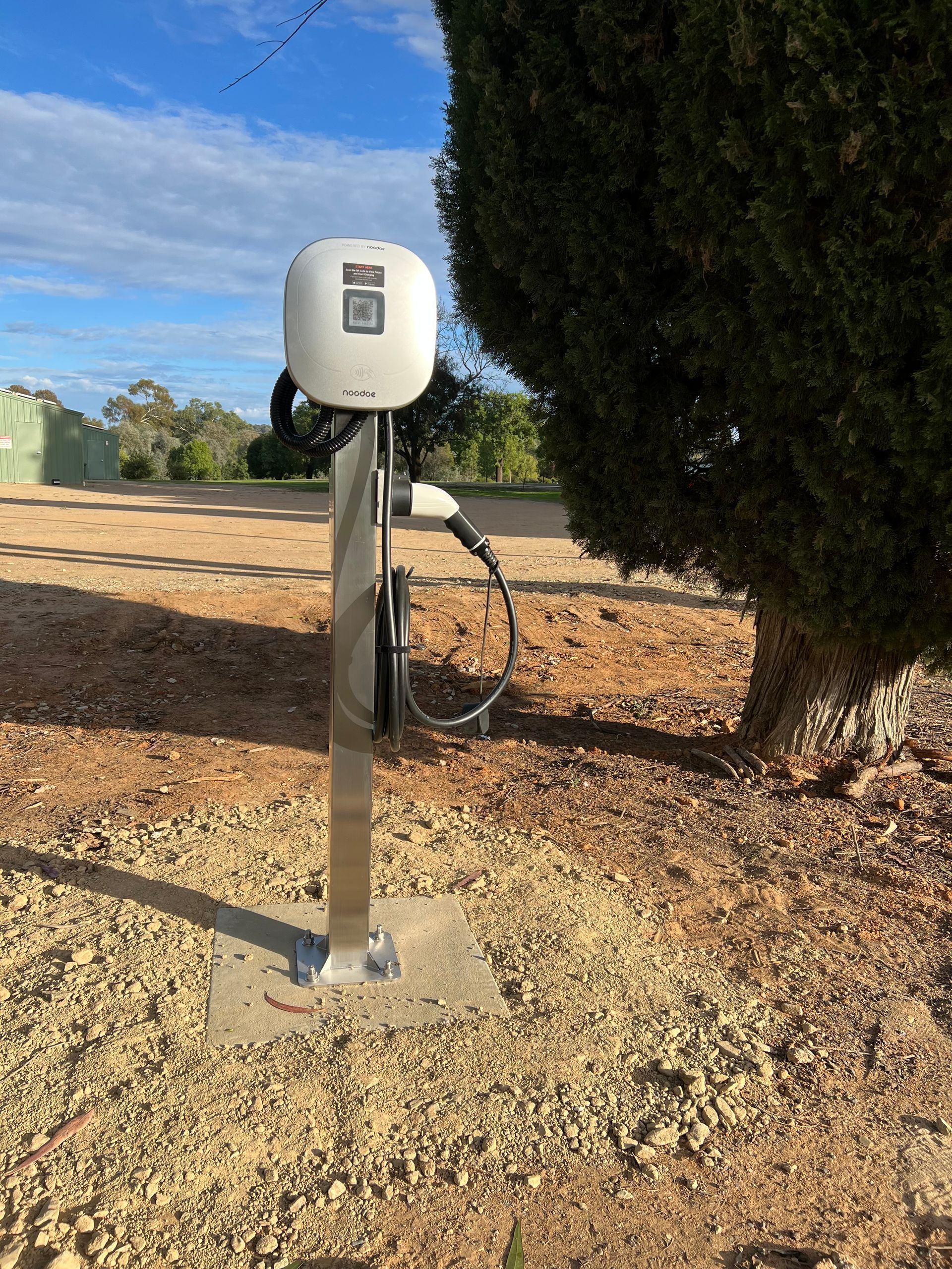 An EV Charger Standing Next To A Tree — Des Mullins Electrical & Solar In Wagga Wagga, NSW