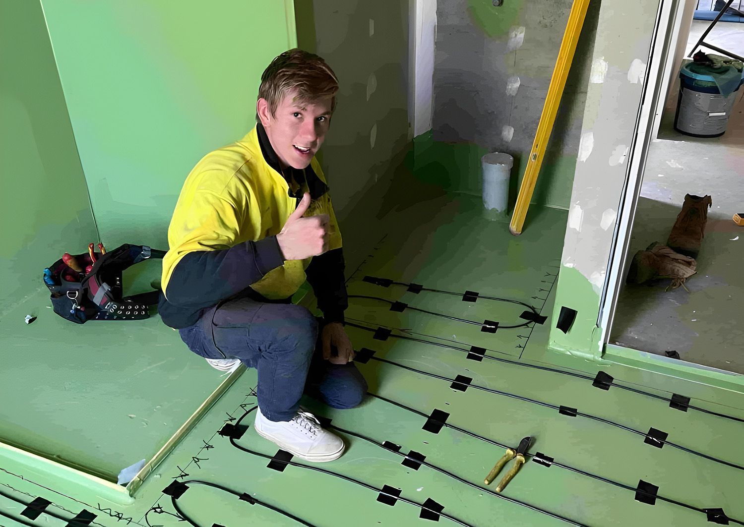 Electrician Gives Thumbs Up, Kneeling On Floor Setting Up Wirings