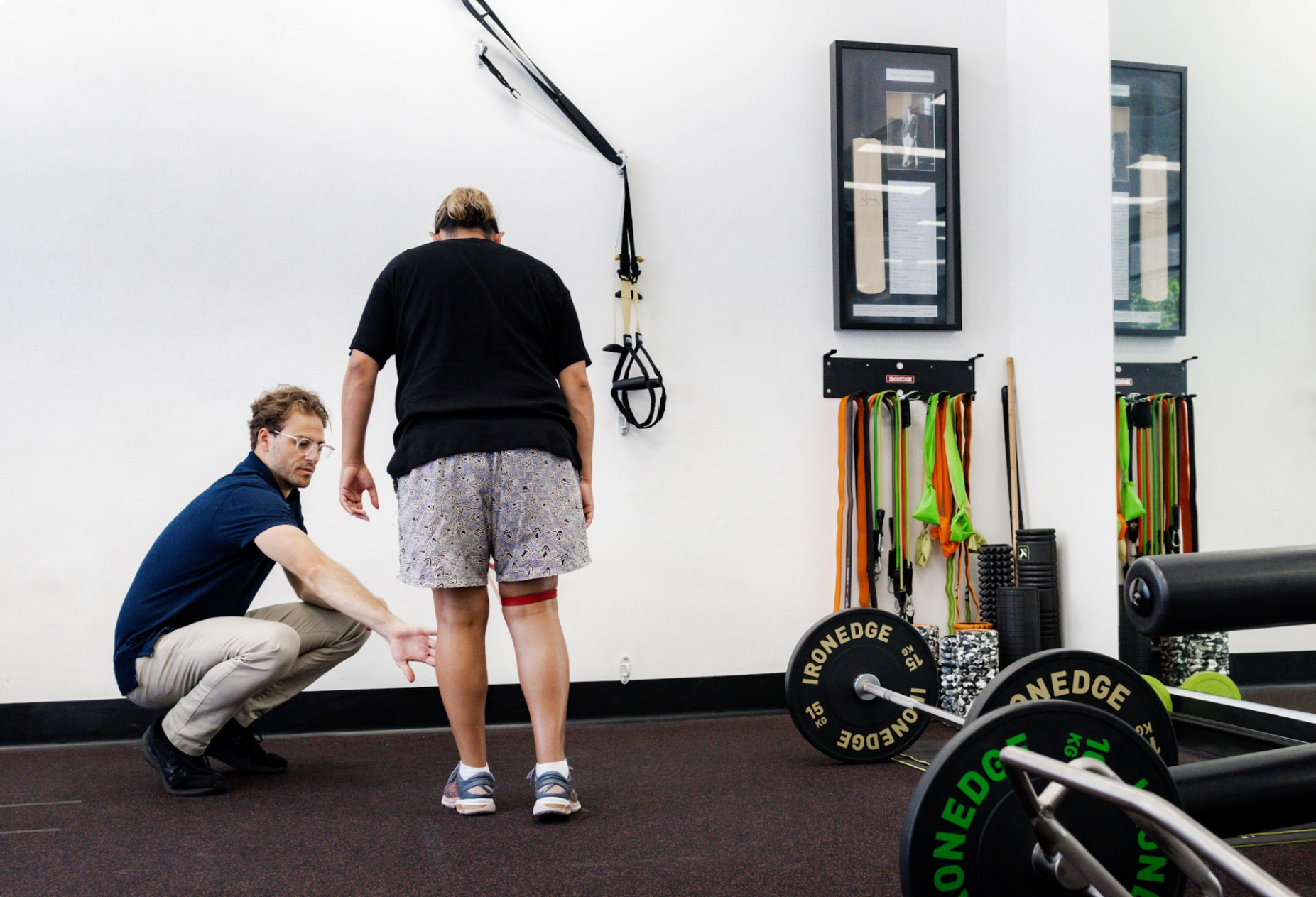 Two men are doing exercises in a gym.