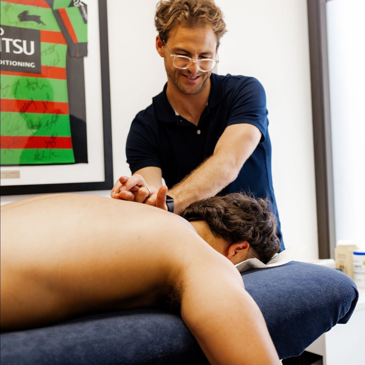 A man gives a woman a high five while she sits on a bench
