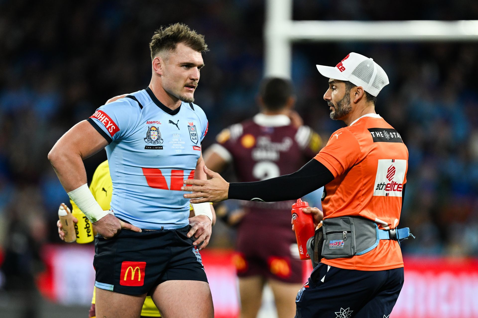 Two rugby players are talking to each other on the field.