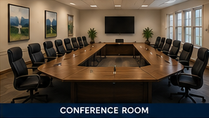 Modern conference room with large wooden table, black chairs, wall-mounted screen, and framed landscape art