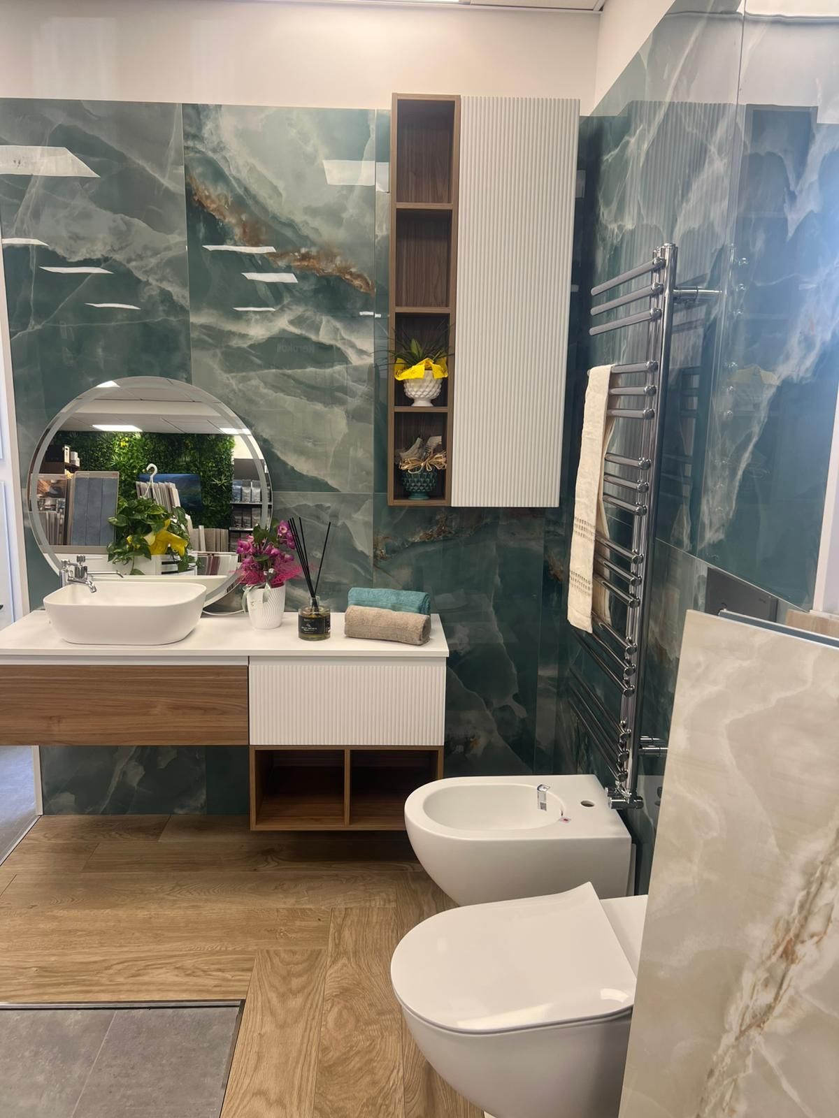 Un bagno con lavandino, water, bidet e specchio.