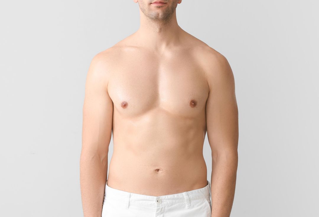 Torso of a person against a gray backdrop, wearing white pants. They have a medium build with visible chest and abdomen.