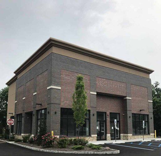 Brown Building With Glass Window — Hillburn, NY — Tri-State Commercial Roofing Corp