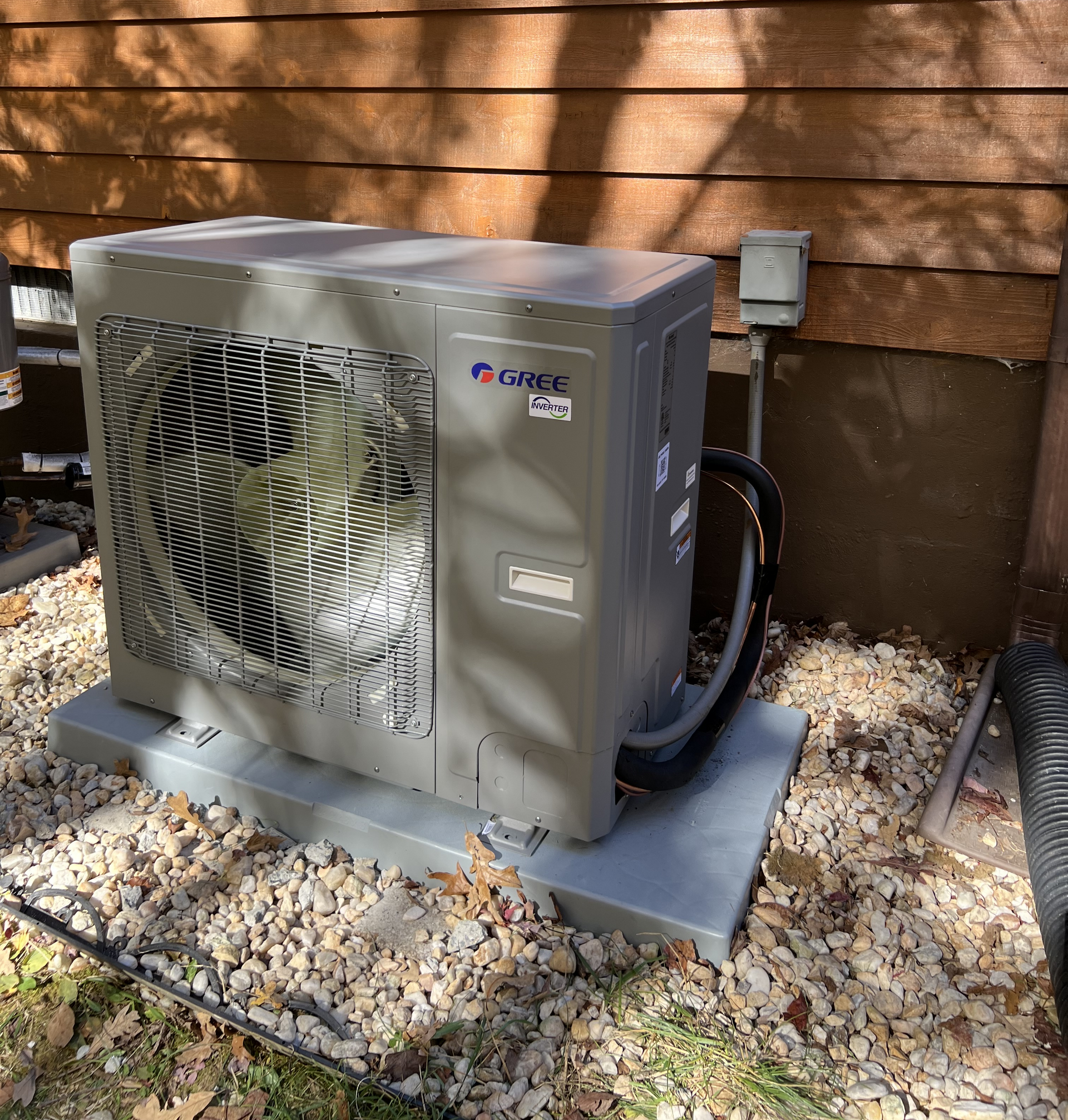 a large air conditioner is sitting on top of a pile of gravel .