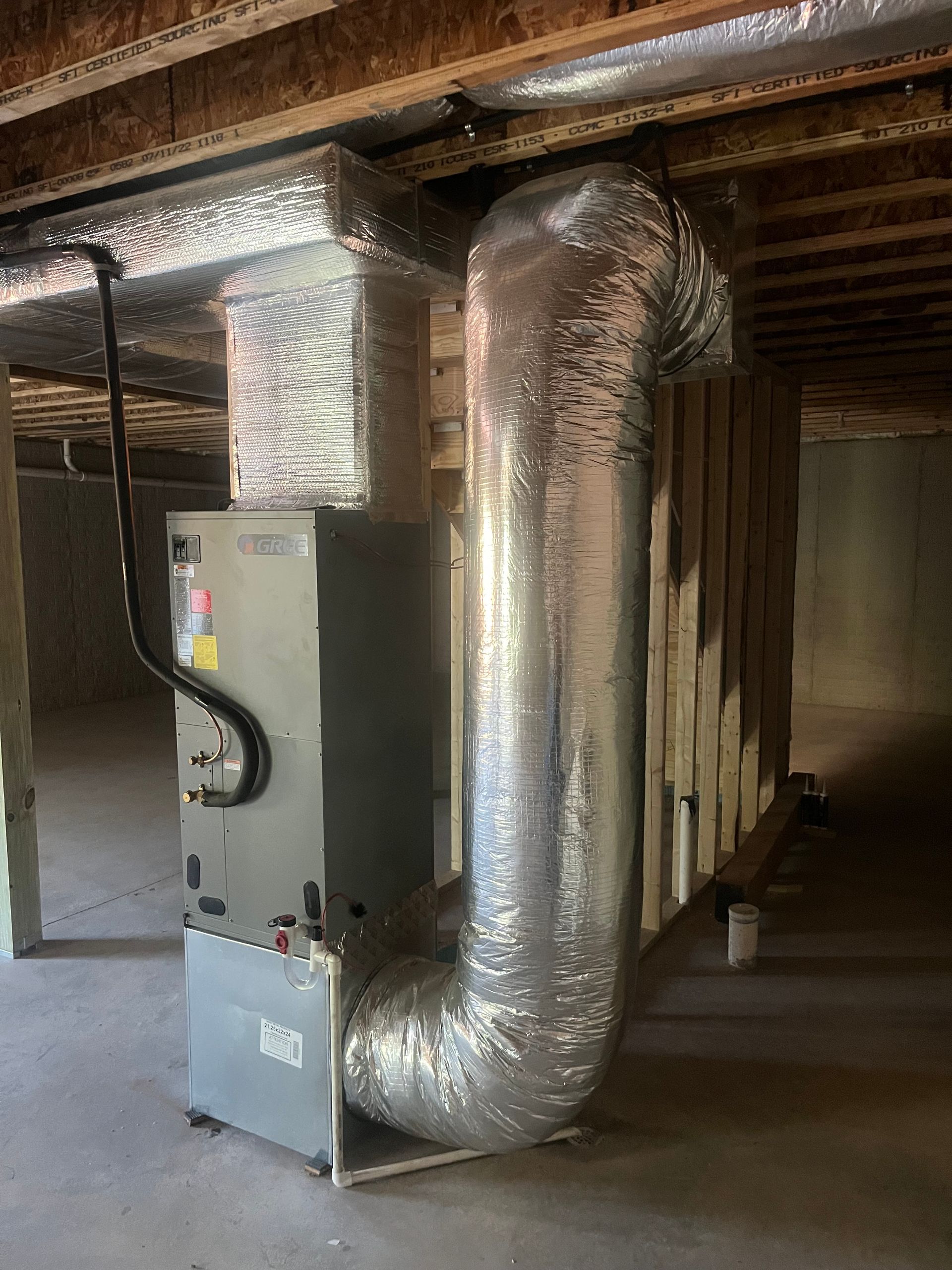 a basement with a furnace and ducts coming out of it .