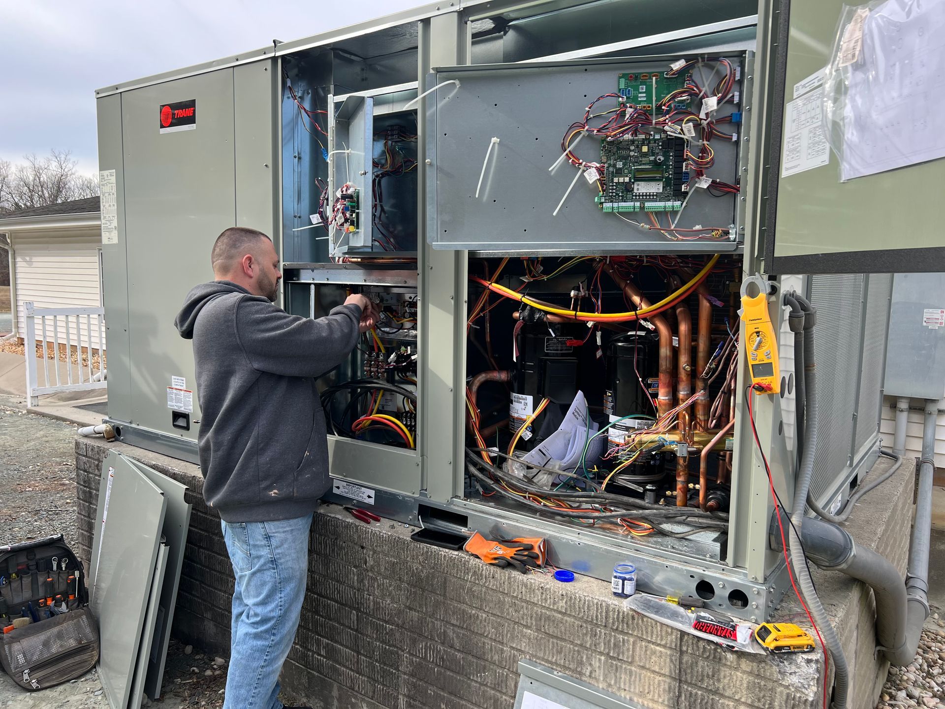 a man is working on an air conditioner outside of a building .