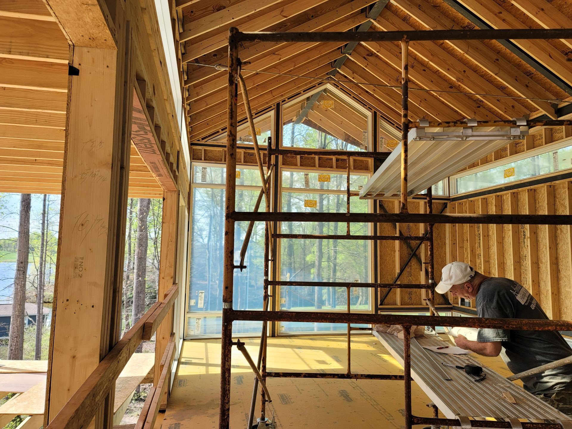 A man is working on a scaffolding in a building under construction.