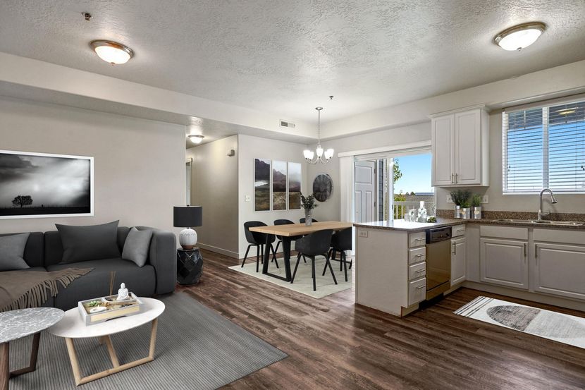 a living room with a couch , table and chairs and a kitchen .
