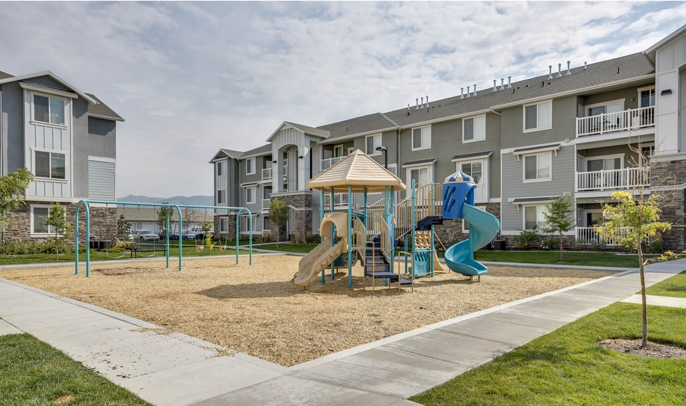 a playground in front of a large apartment building .