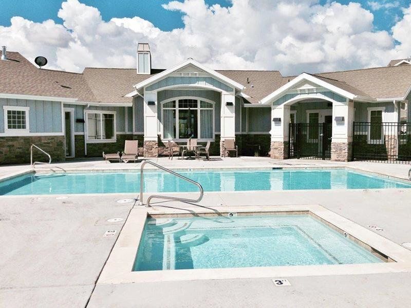 a large house with a swimming pool and a hot tub in front of it