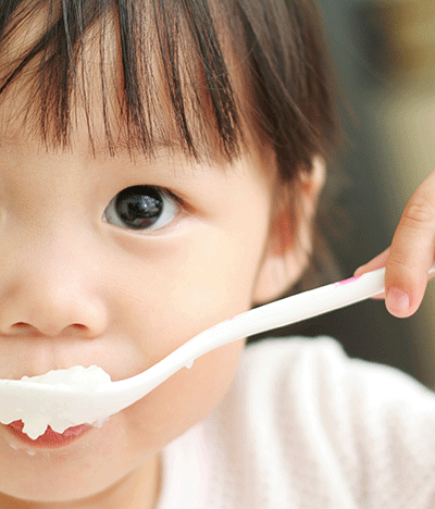 a girl eating with a spoon