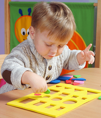 a  toddler playing with shapes and colors