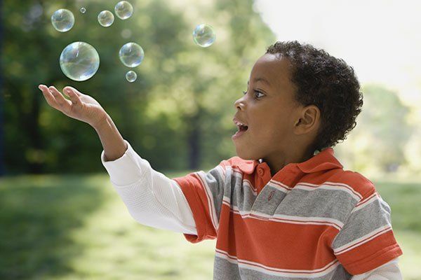 a boy playing with soap bubles